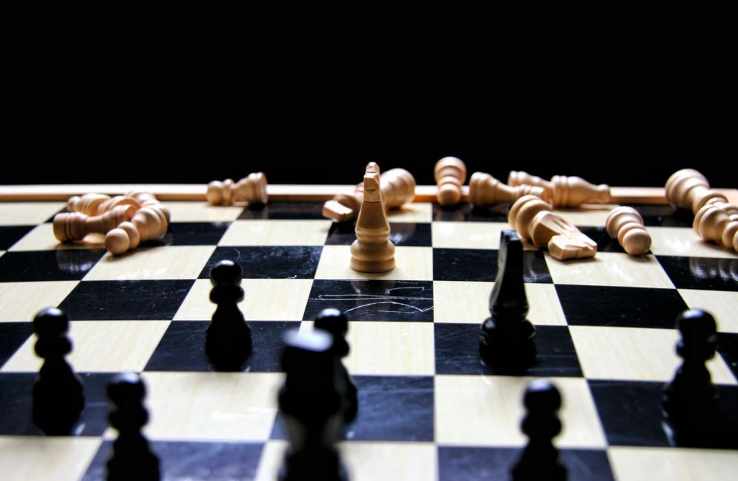 Chess board with pieces knocked over, representing following different rules to the competition